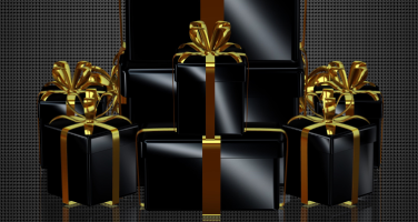 Multiple gift boxes wrapped in black wrapping paper and gold ribbons