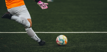 Cropped image of a man kicking a ball