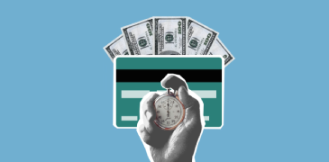A hand holding a timer against the background of a payment card and cash