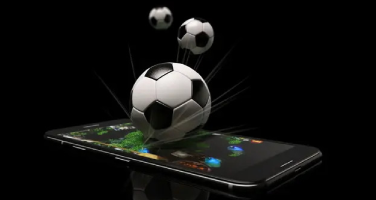 Three footballs over a mobile phone which is laying flat